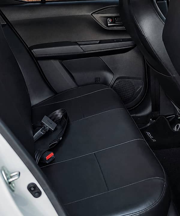 Close-up of black rear car seats with a seatbelt visible.