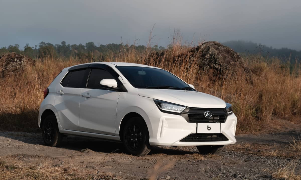 White Agya parked on a dirt road with dry grass and hills in the background.