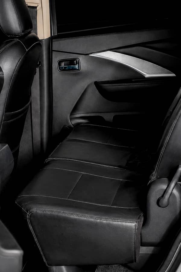 Interior view of Mitsubishi Xpander backseat with black seats and visible seatbelts.